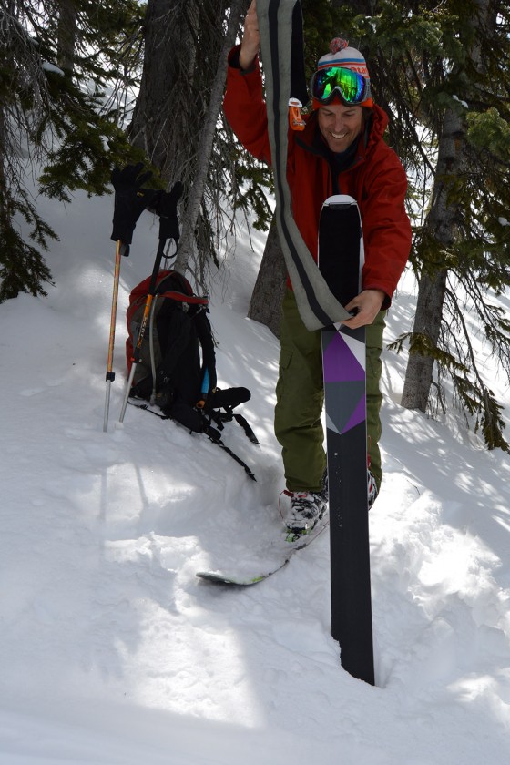 Easy there cowboy. One hand on the pole for balance while the other hand places the pre-folded skin over the tip of the ski. 